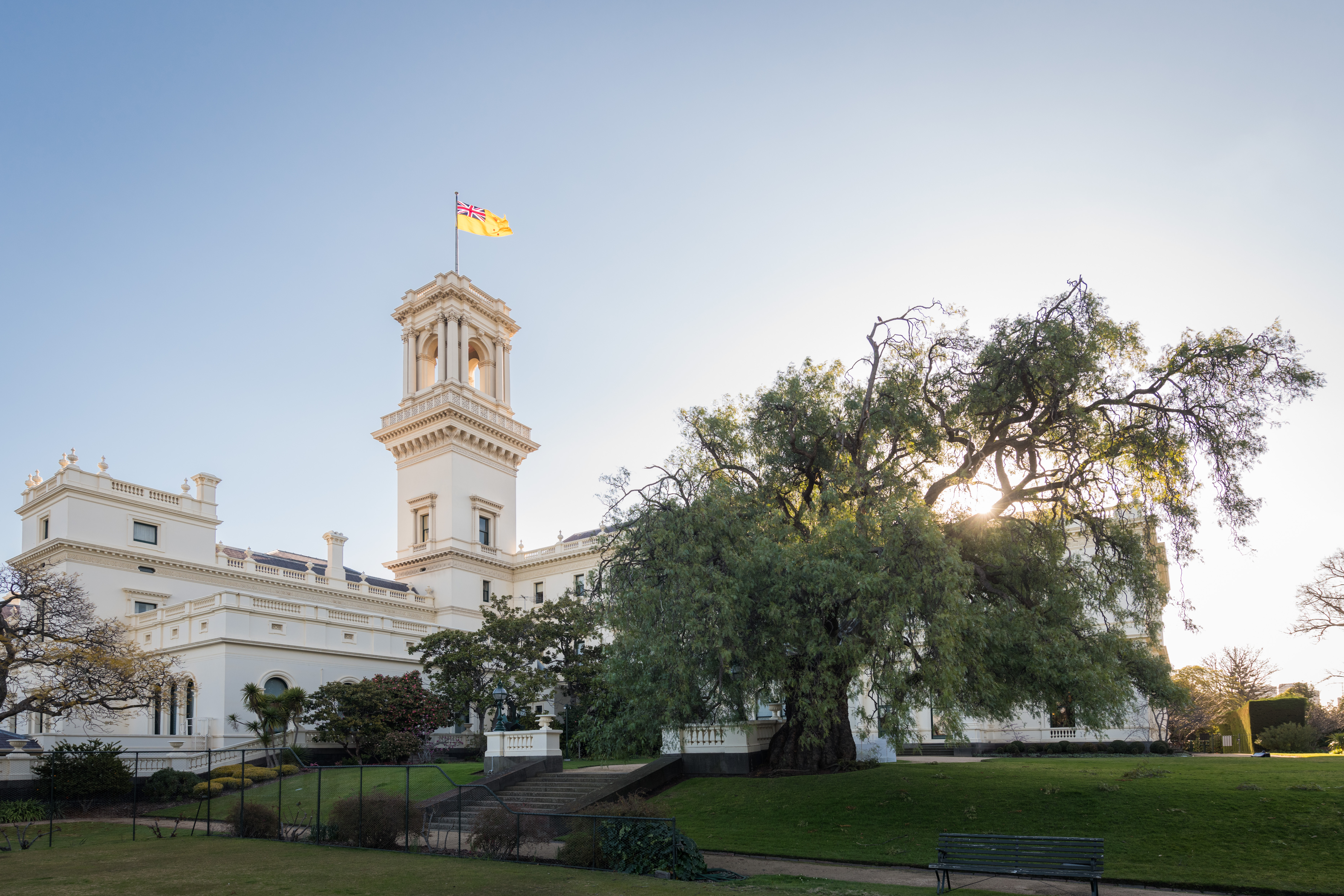 Peppercorn tree in the gardens at Government House Victoria with Governor's Standard flying atop the tower