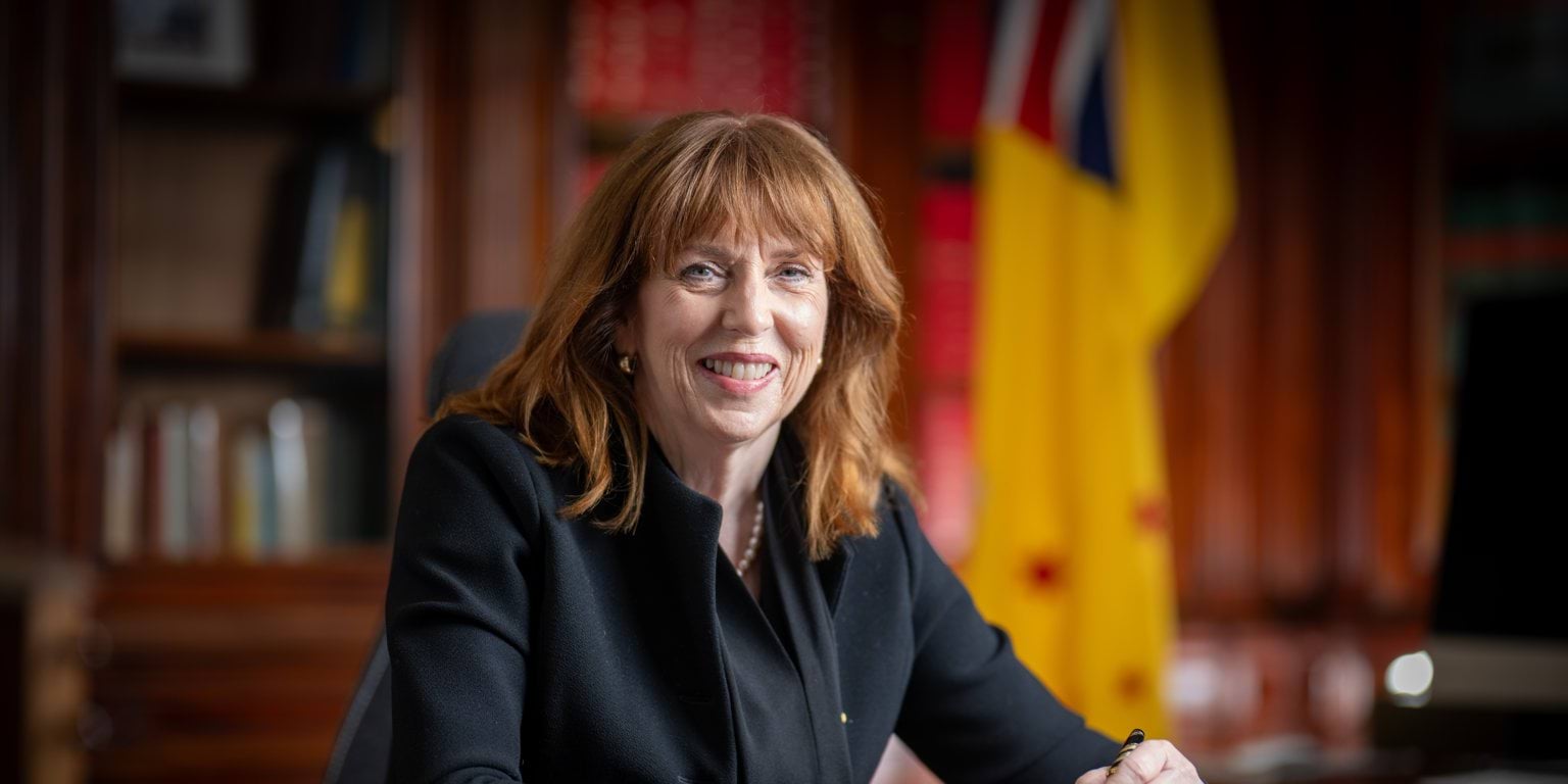 Her Excellency Professor the Honourable Margaret Gardner AC seated at a desk